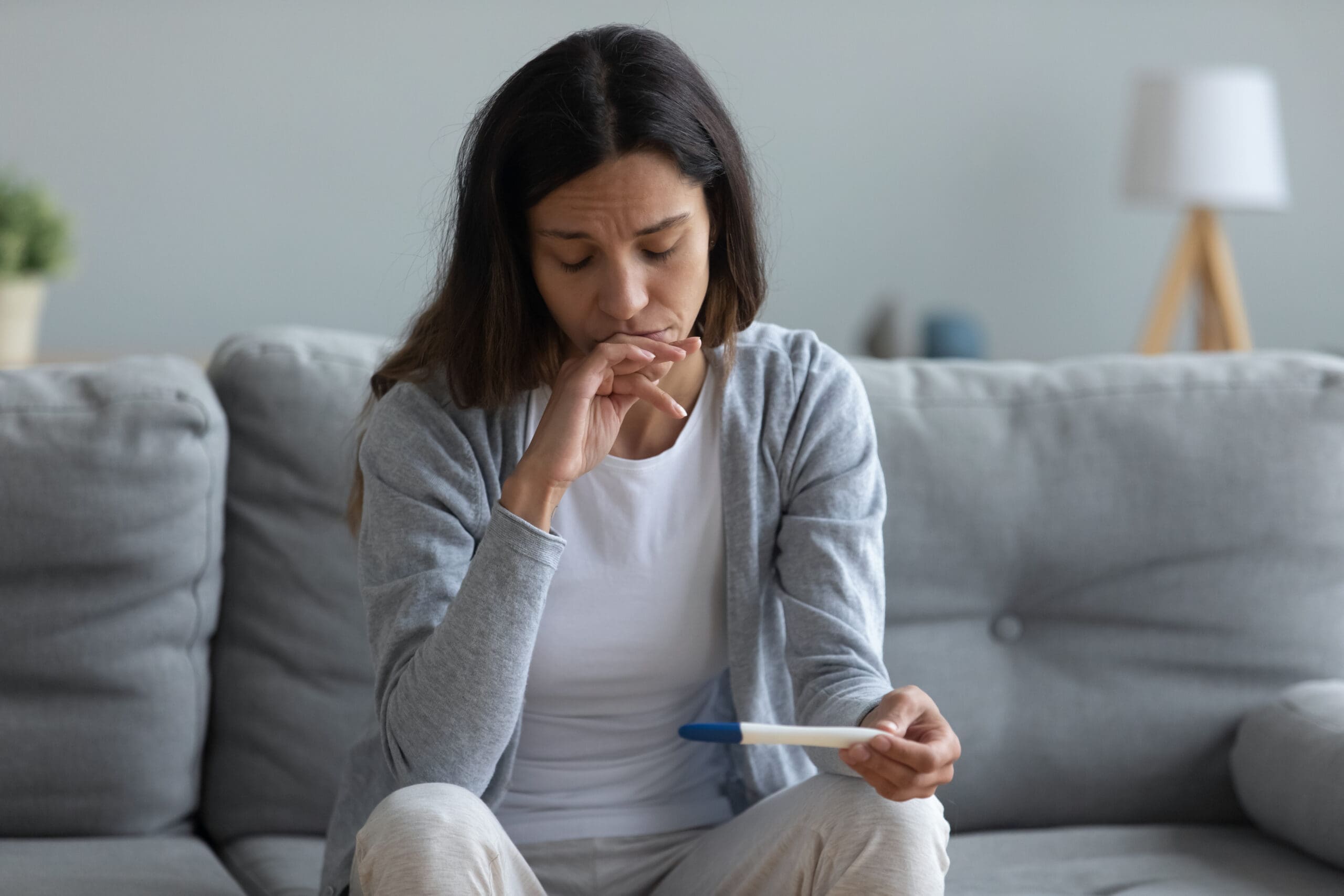 Upset young woman frustrated with pregnancy test results