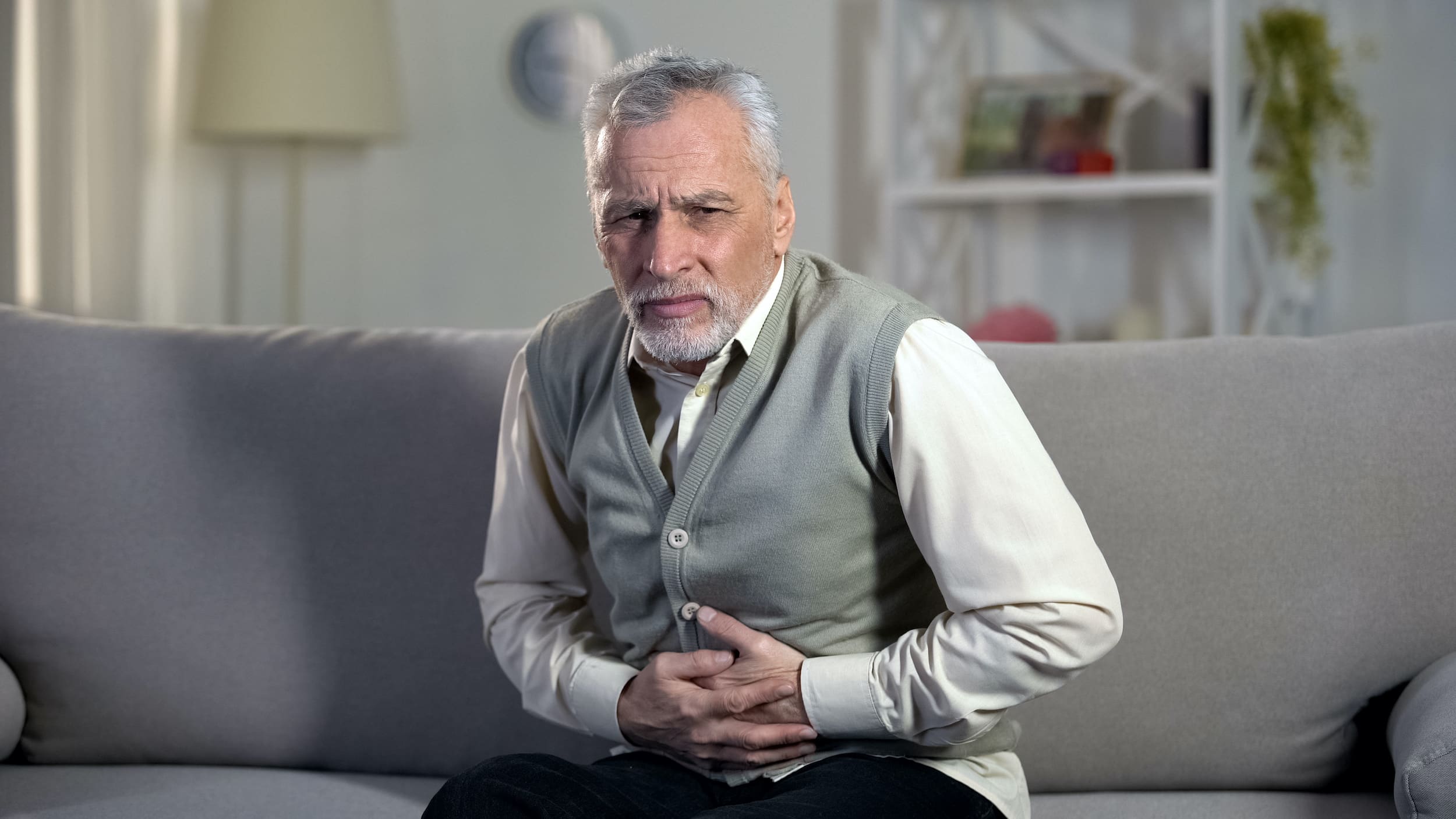 Elder male suffering stomach ache, sharp cramps in upper abdomen, indigestion Hernia